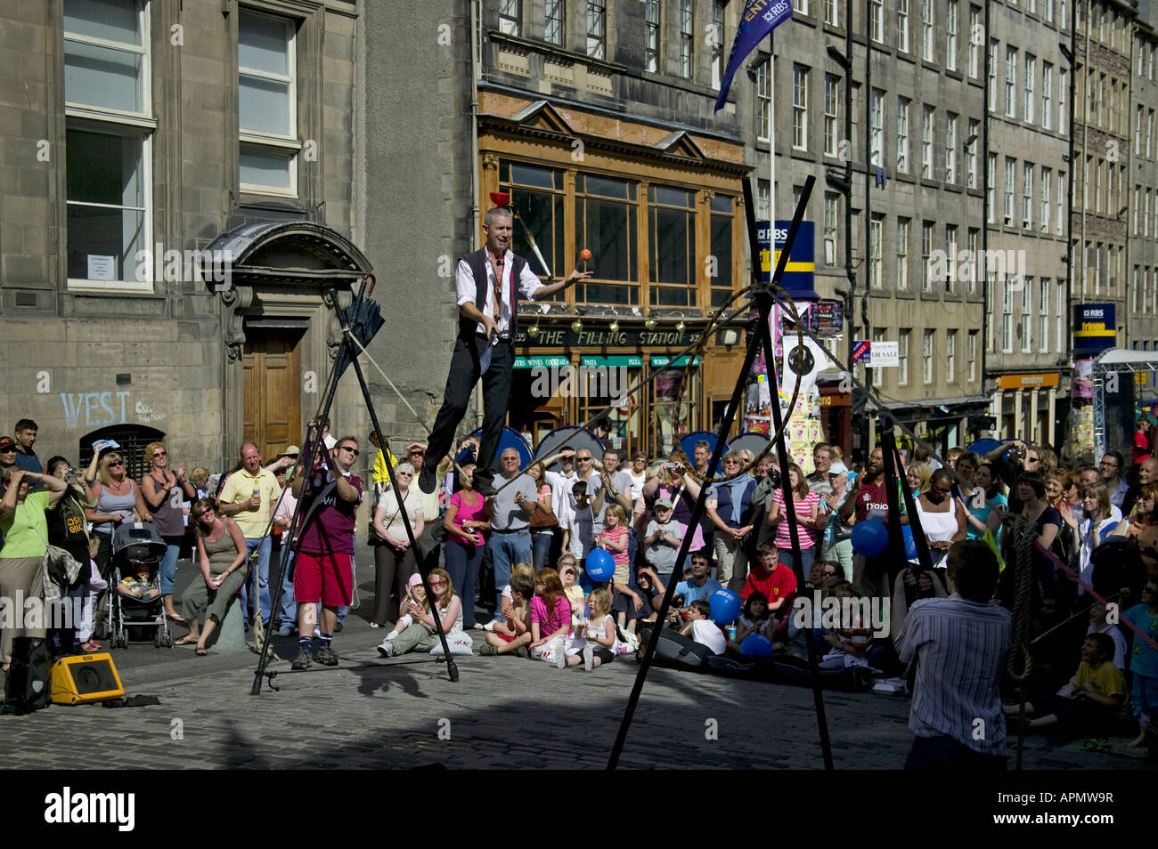 Edinburgh Fringe street performer walking slack rope juggling knife and apple, Scotland UK Europe Stock Photo