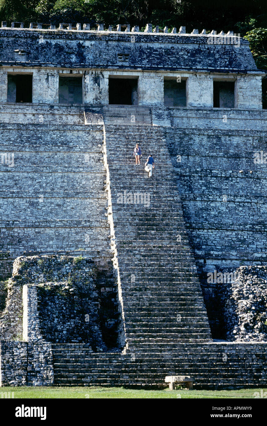 Two people descend the long flight of steps which lead to the Pyramid of the Inscriptions at the Mayan site at Palenque The stepped pyramid rises to a summit temple and descends 25 metres inside to the tomb of King Pakal Stock Photo