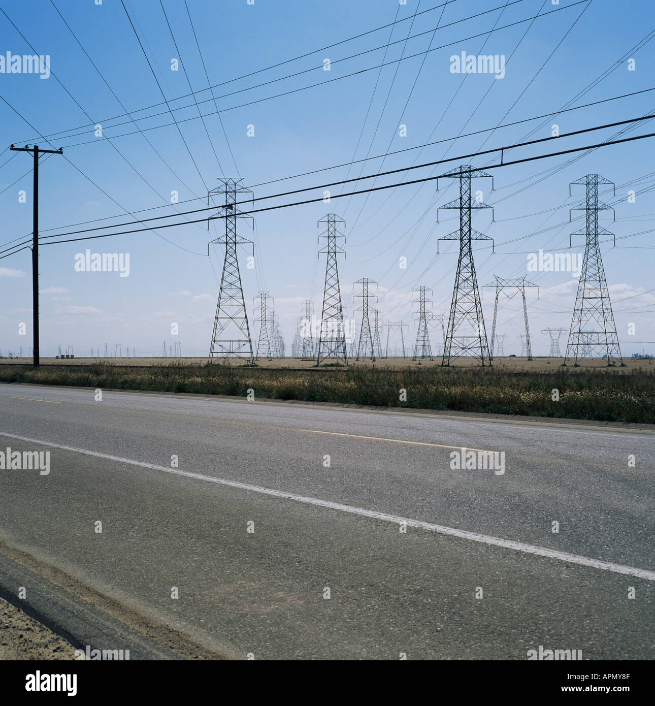 Pylons and power lines by a road Stock Photo