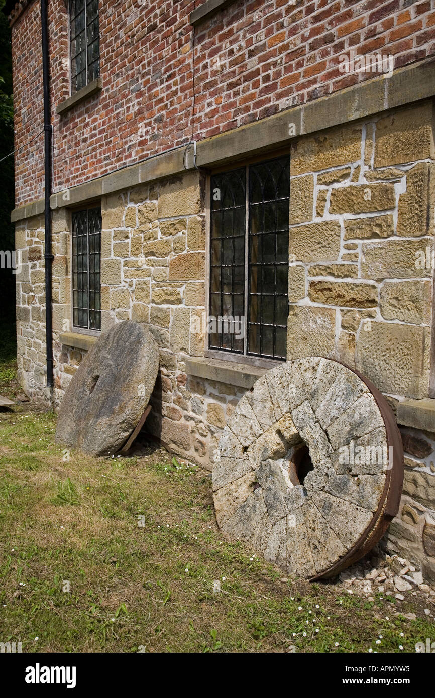 Mill wheels for flour grinding leaning against the wall of the mill at