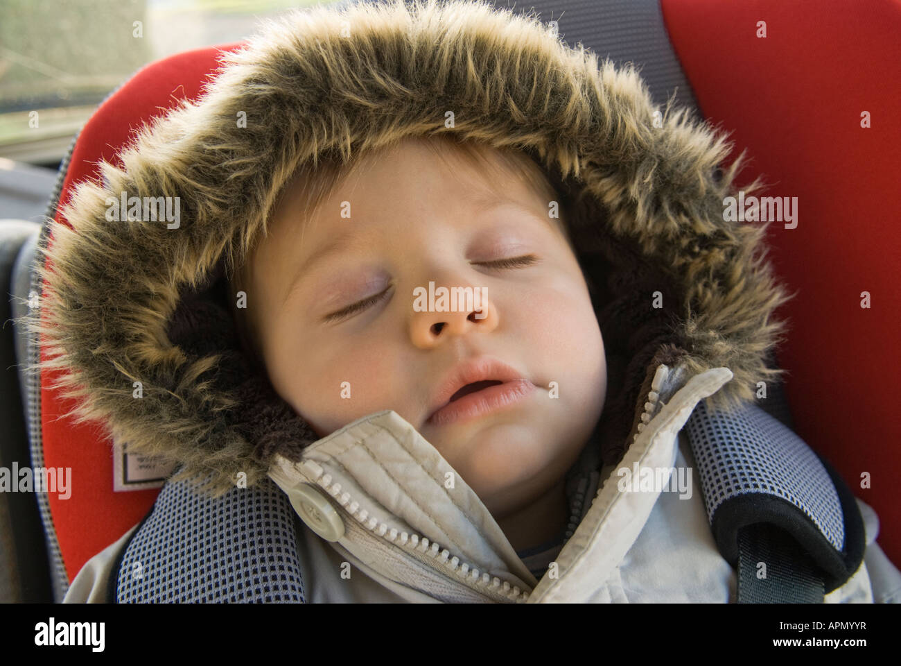 Baby boy eleven months old asleep in car seat after trip to playground