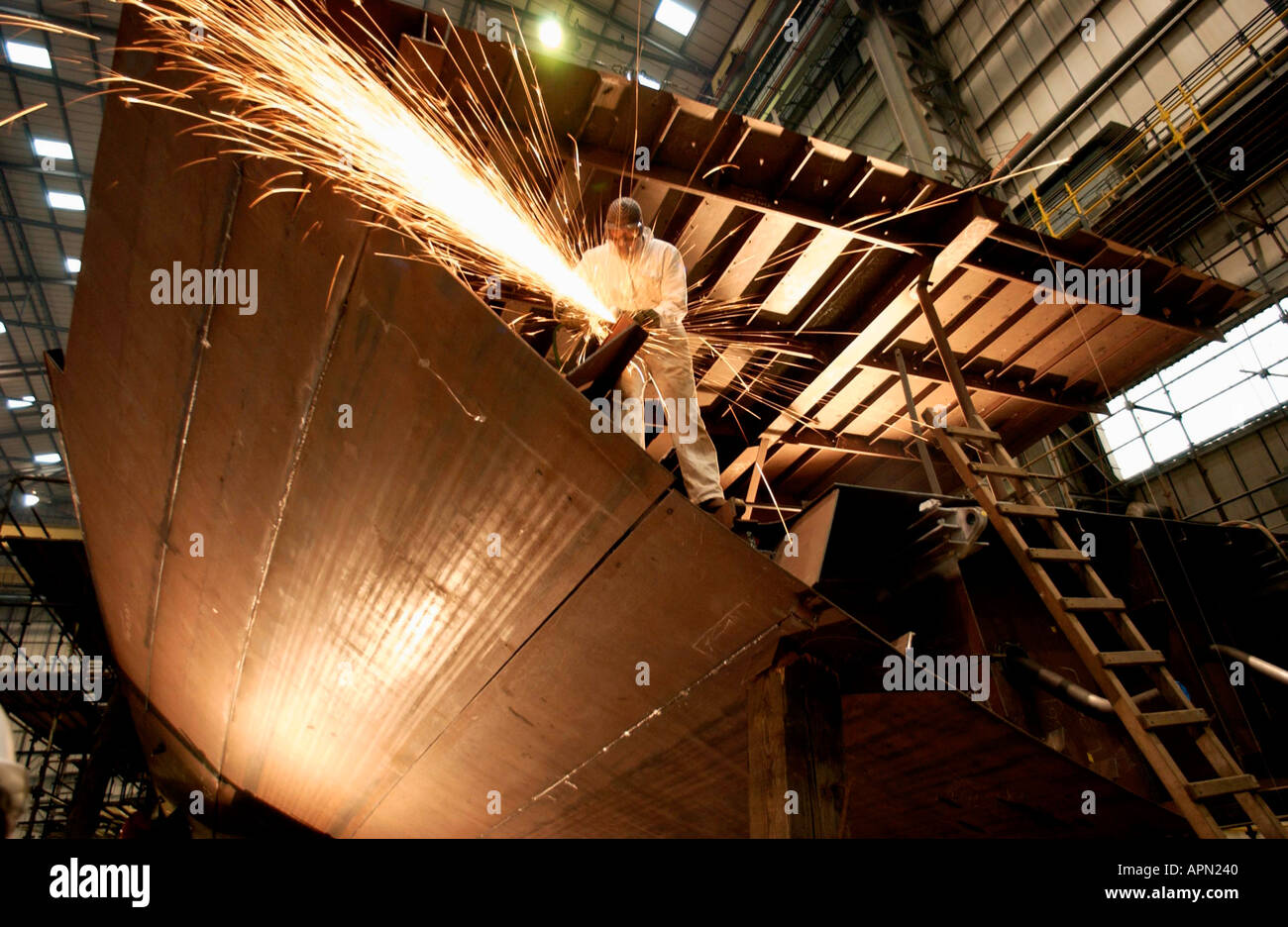 At shipbuilders Vosper Thornycroft  a plater welds plates on the bulkhead of HMS Tyne a  Royal Navy offshore patrol vessel Stock Photo