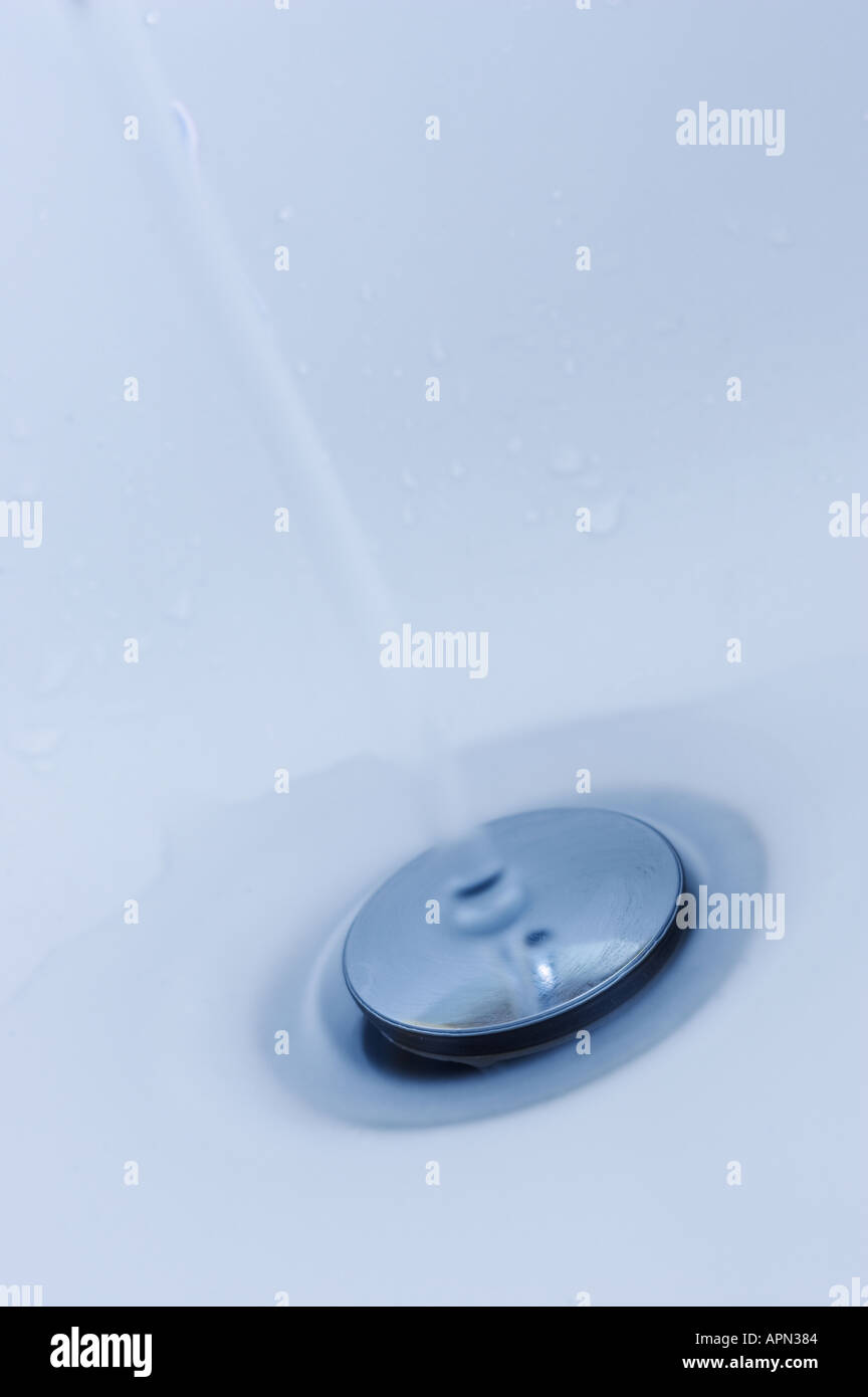 Water running onto popup sink waste Stock Photo