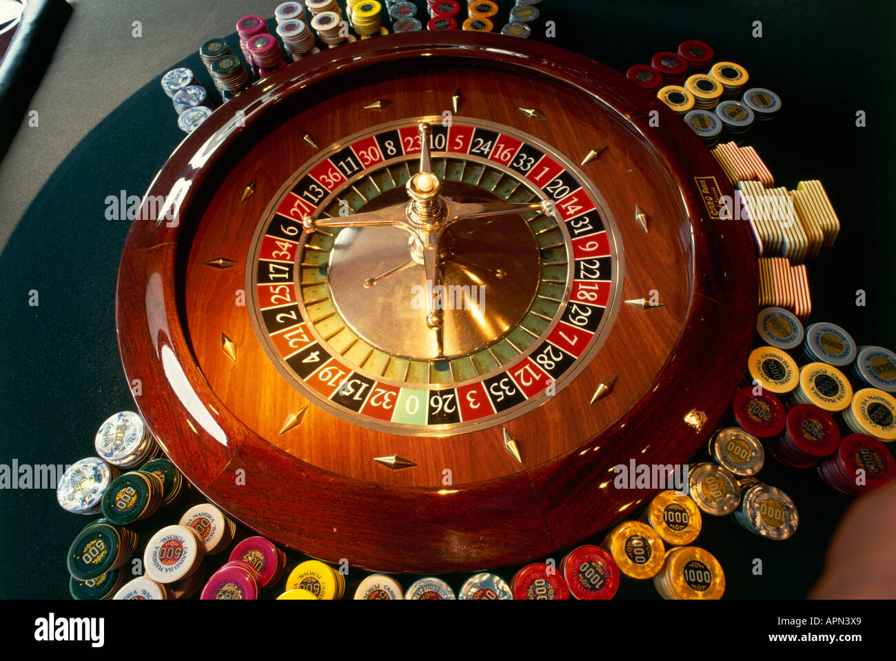 Detail of the roulette wheel and heaps of counters and gaming chips in