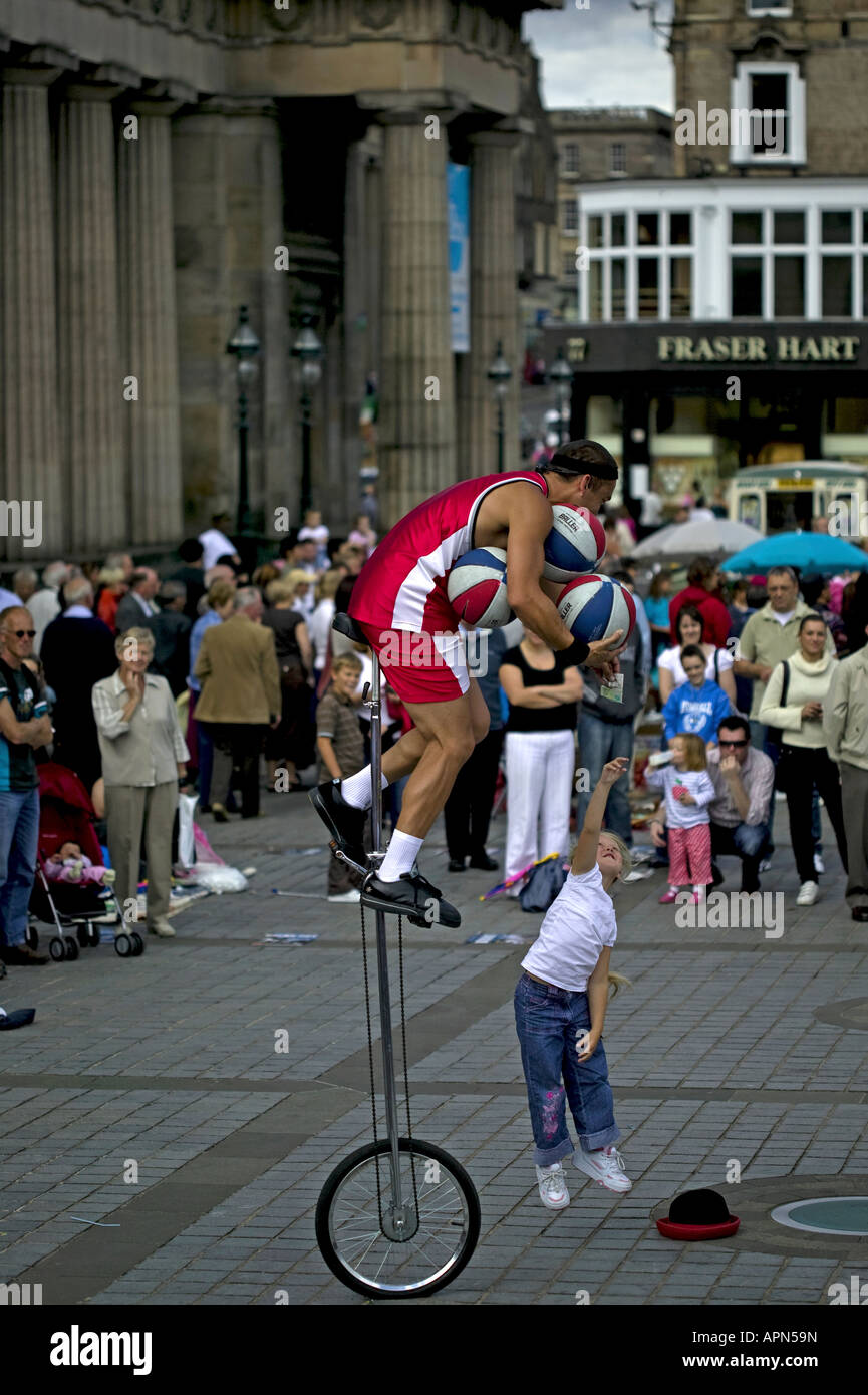 Street perfomer teasing young girl by making her jump for cash, Edinburgh Fringe Festival Scotland Europe Stock Photo