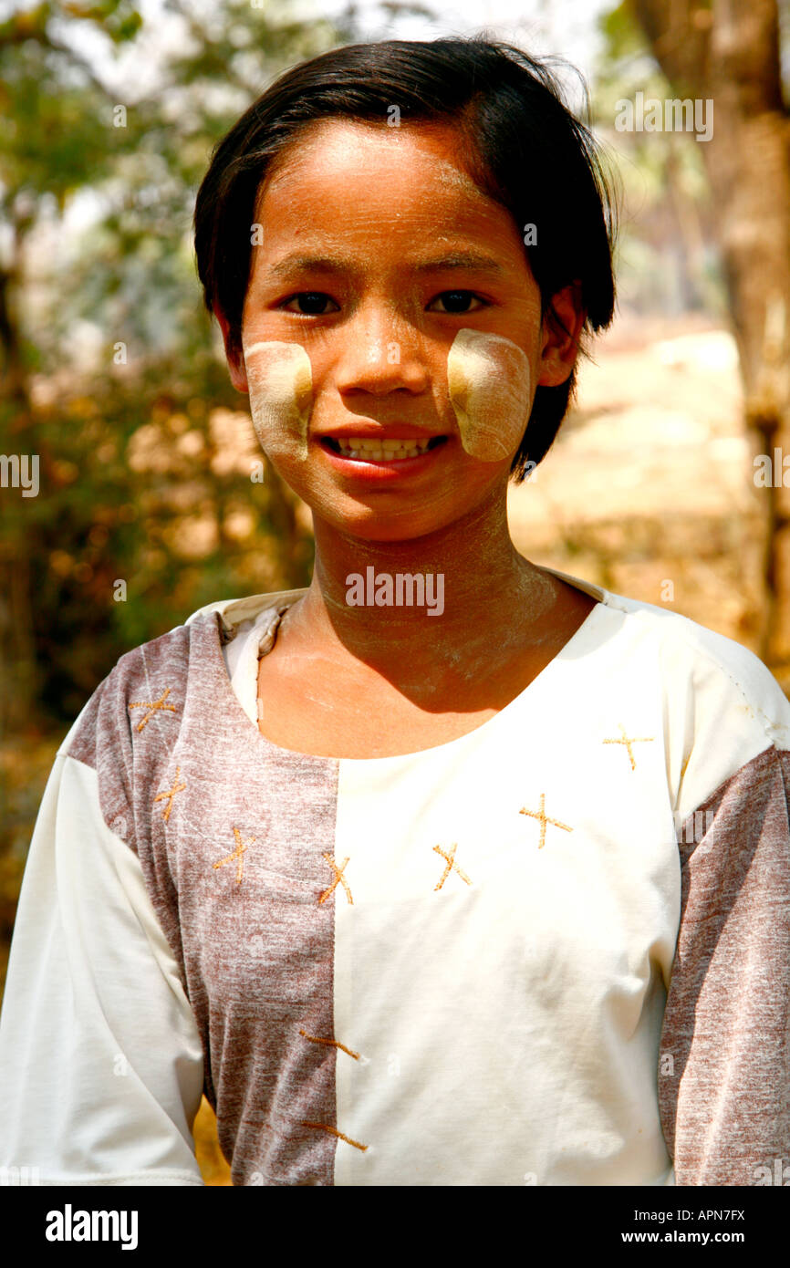 A young Burmese village girl poses for a portrait wearing the iconic