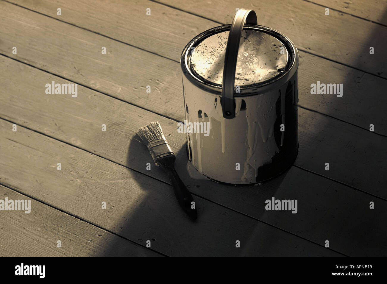 Paint can and brush on wooden floorboards Stock Photo Alamy