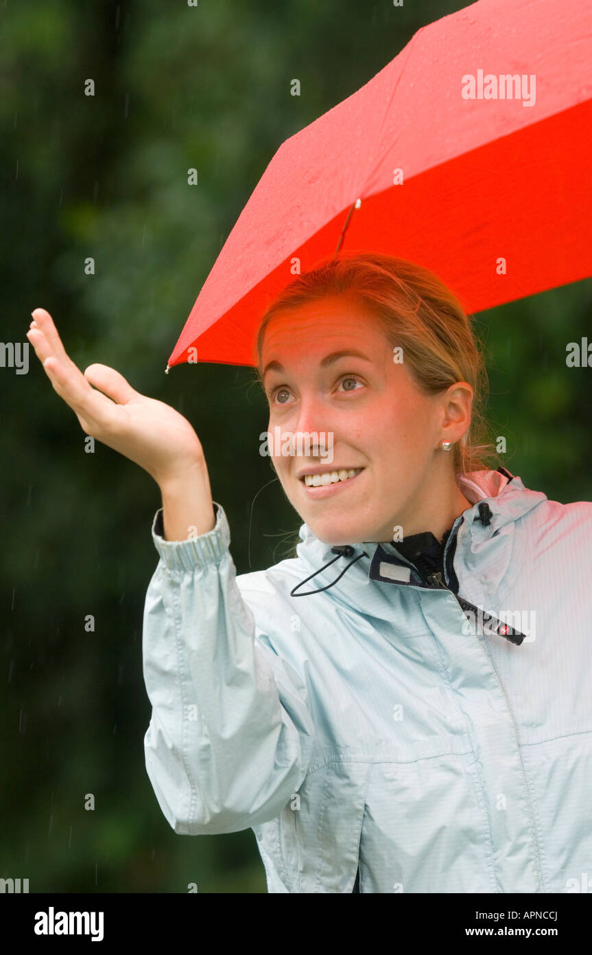 Woman and red umbrella checking for rain, Costa Rica Stock Photo Alamy