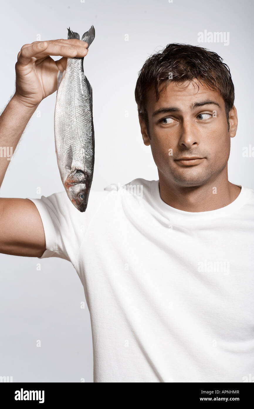 Mid adult man holding striped sea bass Stock Photo