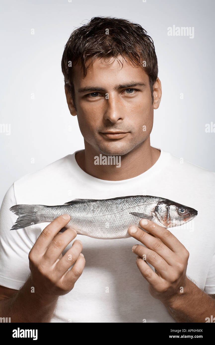 Mid adult man holding striped sea bass Stock Photo
