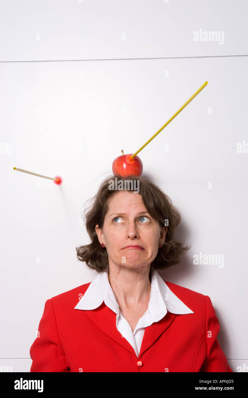 Shooting apple off businesswoman s head Stock Photo