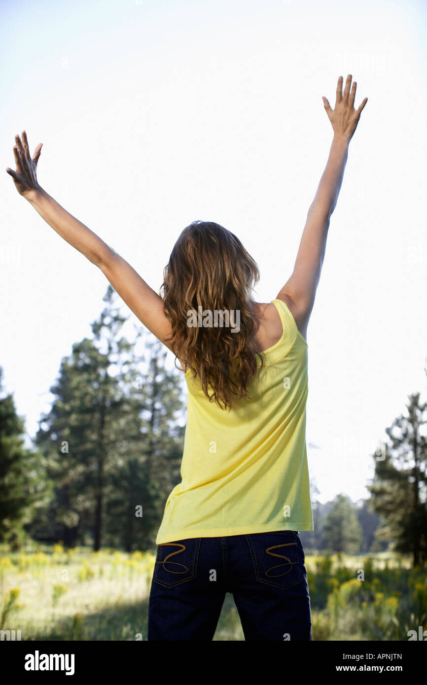 Young woman raising hands Stock Photo - Alamy