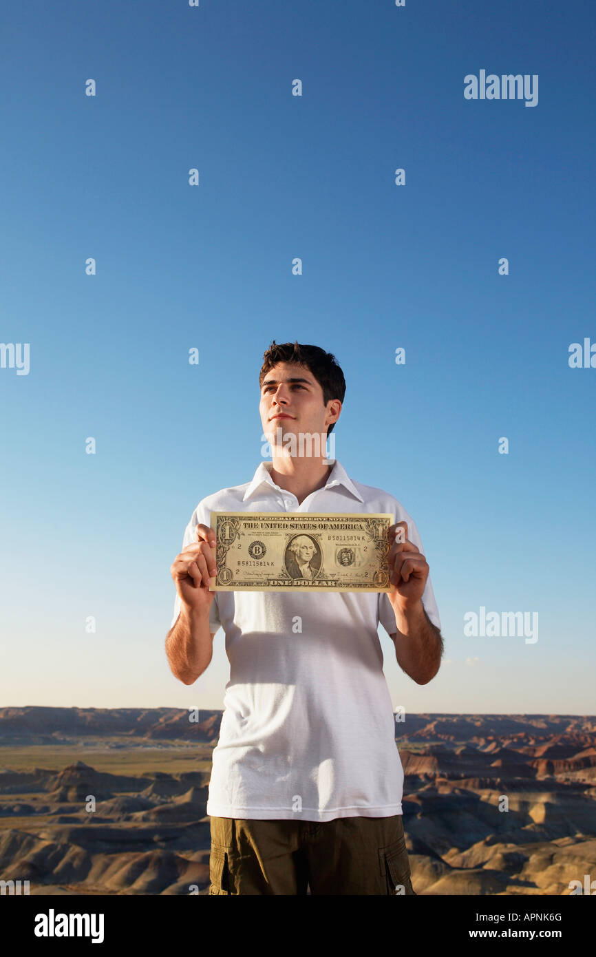 Young man holding large one dollar bill stock photo alamy