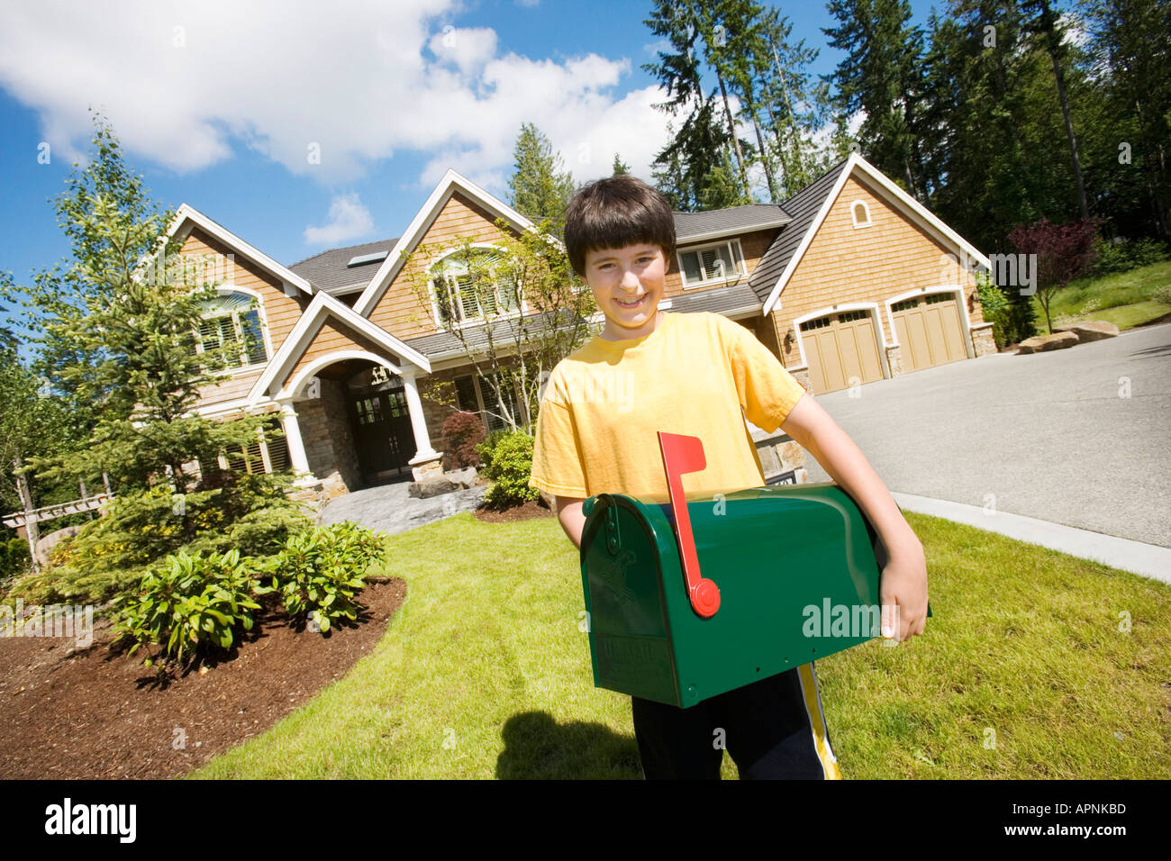 Boy carrying mailbox on front lawn Stock Photo - Alamy