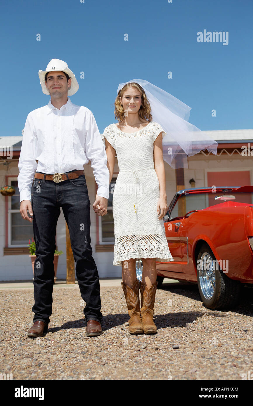 Portrait of newlyweds in cowboy attire at motel (low angle view) Stock Photo