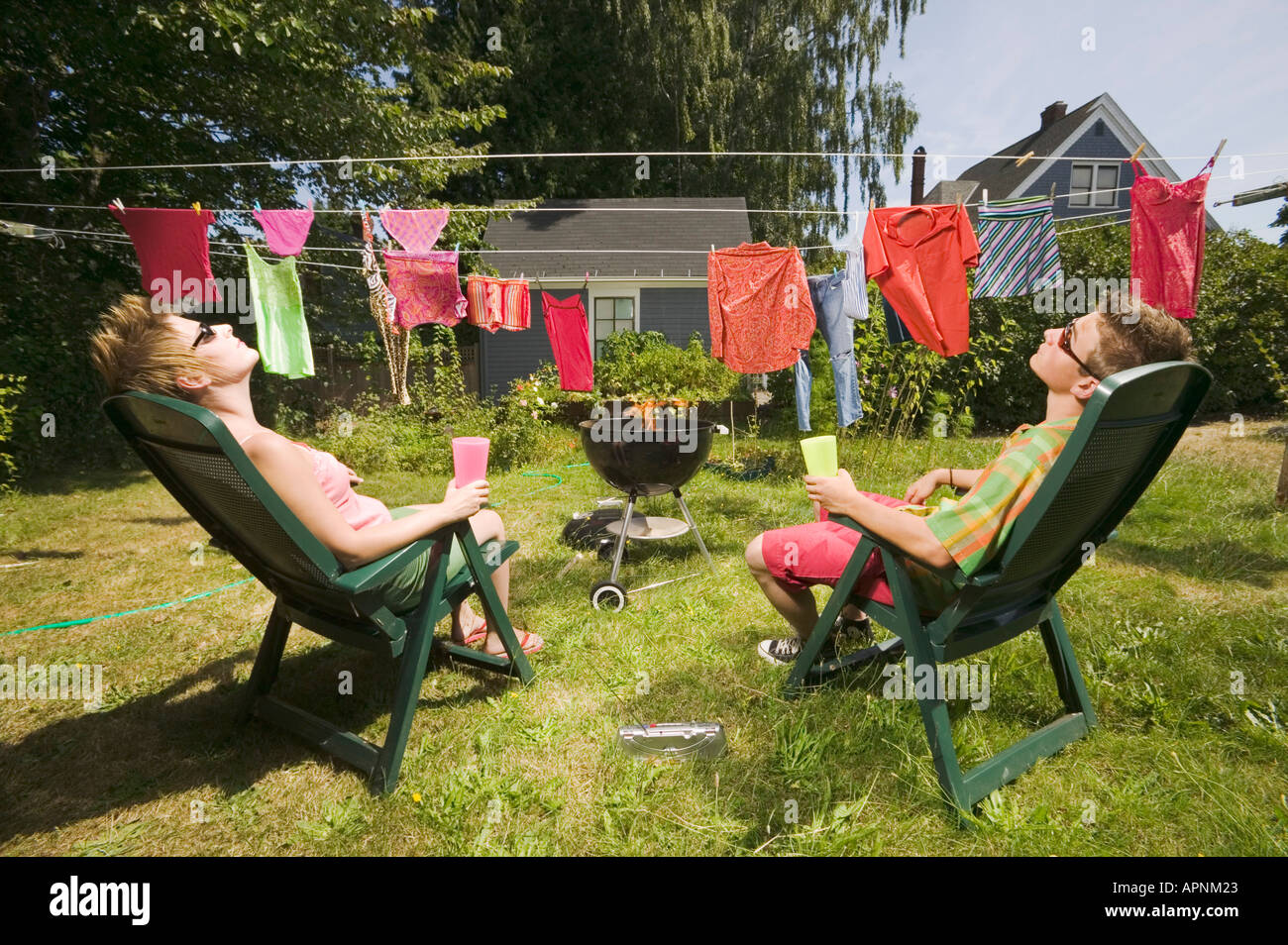 Couple sunbathing in back yard Stock Photo Alamy