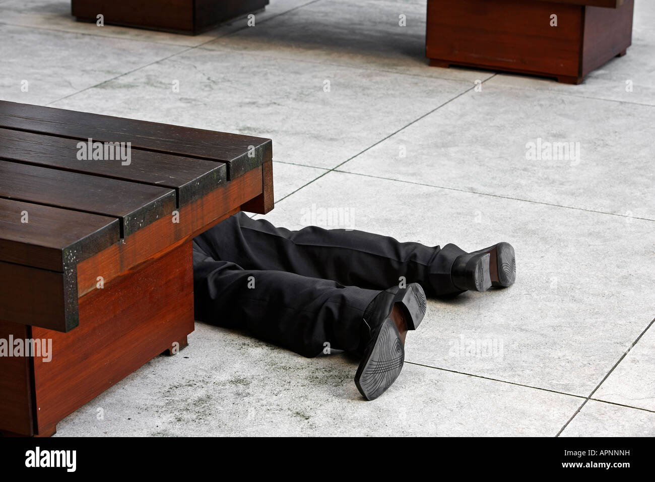 Low Section of Businessman Lying on Tiled Floor Stock Photo