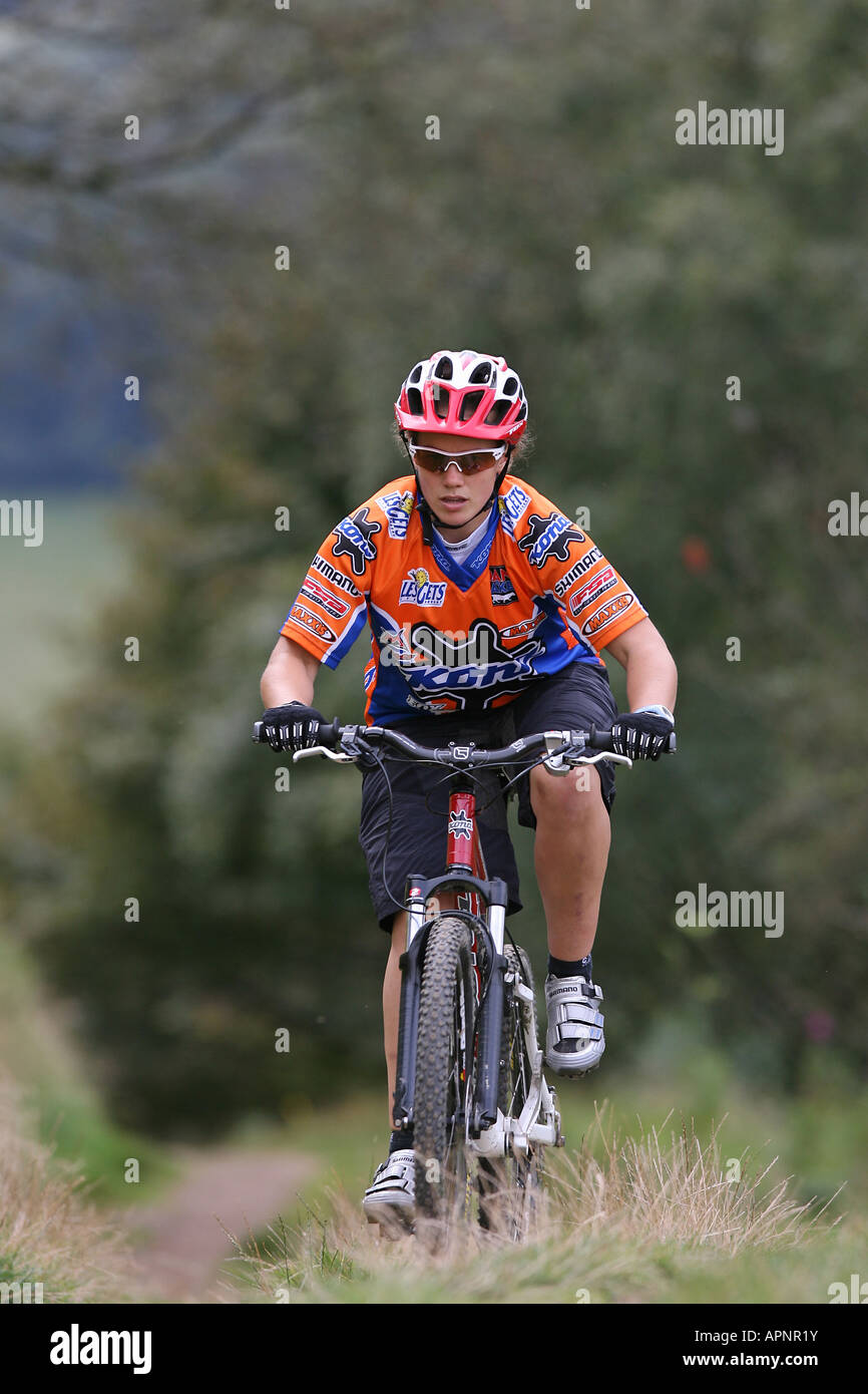 Young Woman riding a Mountain Bike uphill Stock Photo Alamy