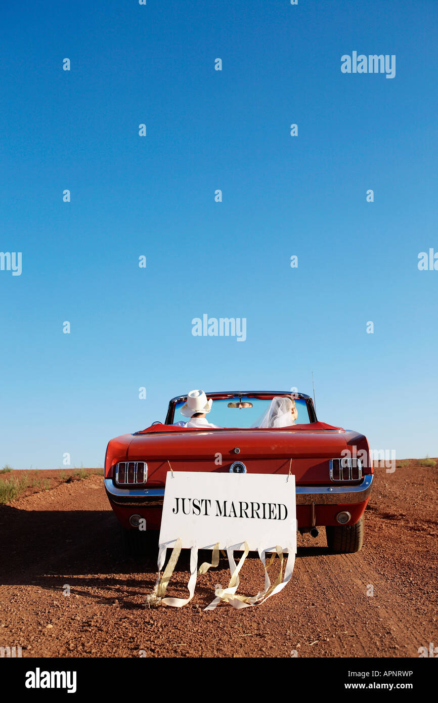 Newlyweds driving convertible through desert, Arizona, USA Stock Photo