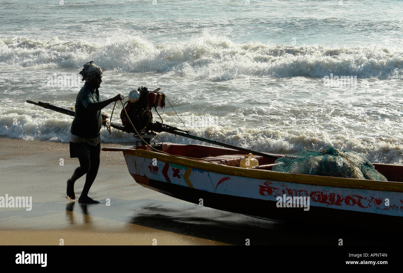 indian fisherman with local fishing boat on the beach at chennai Stock