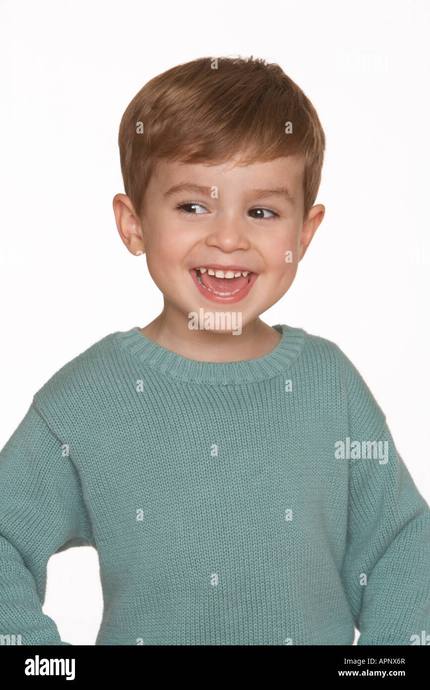 a boy in a blue jumper smiles against a white background Stock Photo Alamy