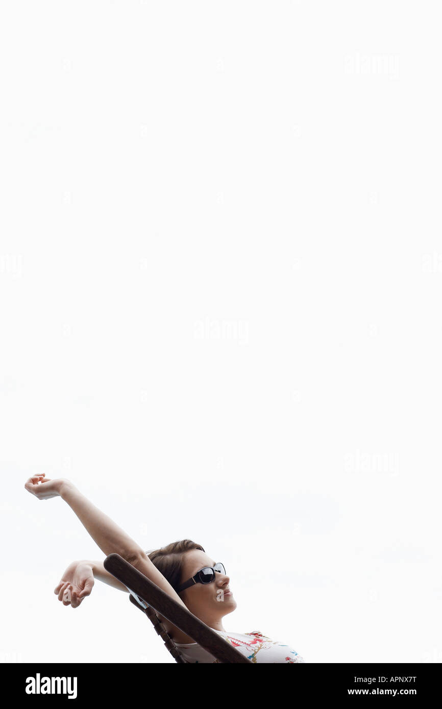 Young woman stretching on lounge chair Stock Photo