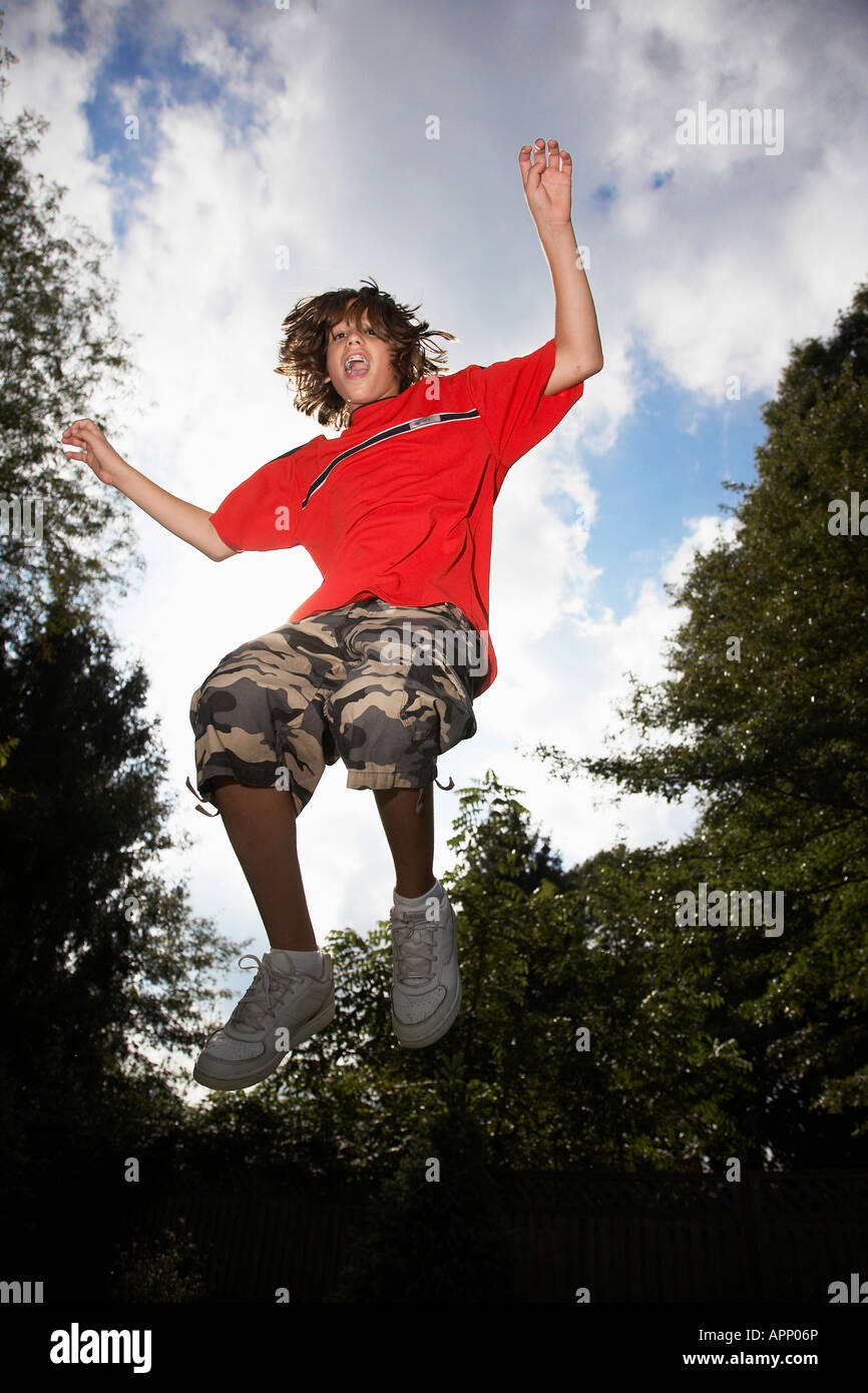 Low angle view of boy (12-13) jumping Stock Photo