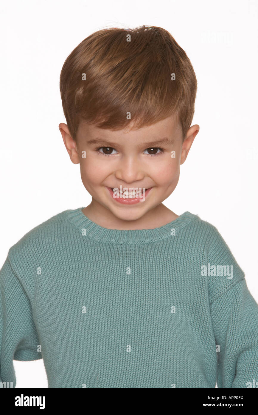 a boy in a blue jumper smiles against a white background Stock Photo Alamy
