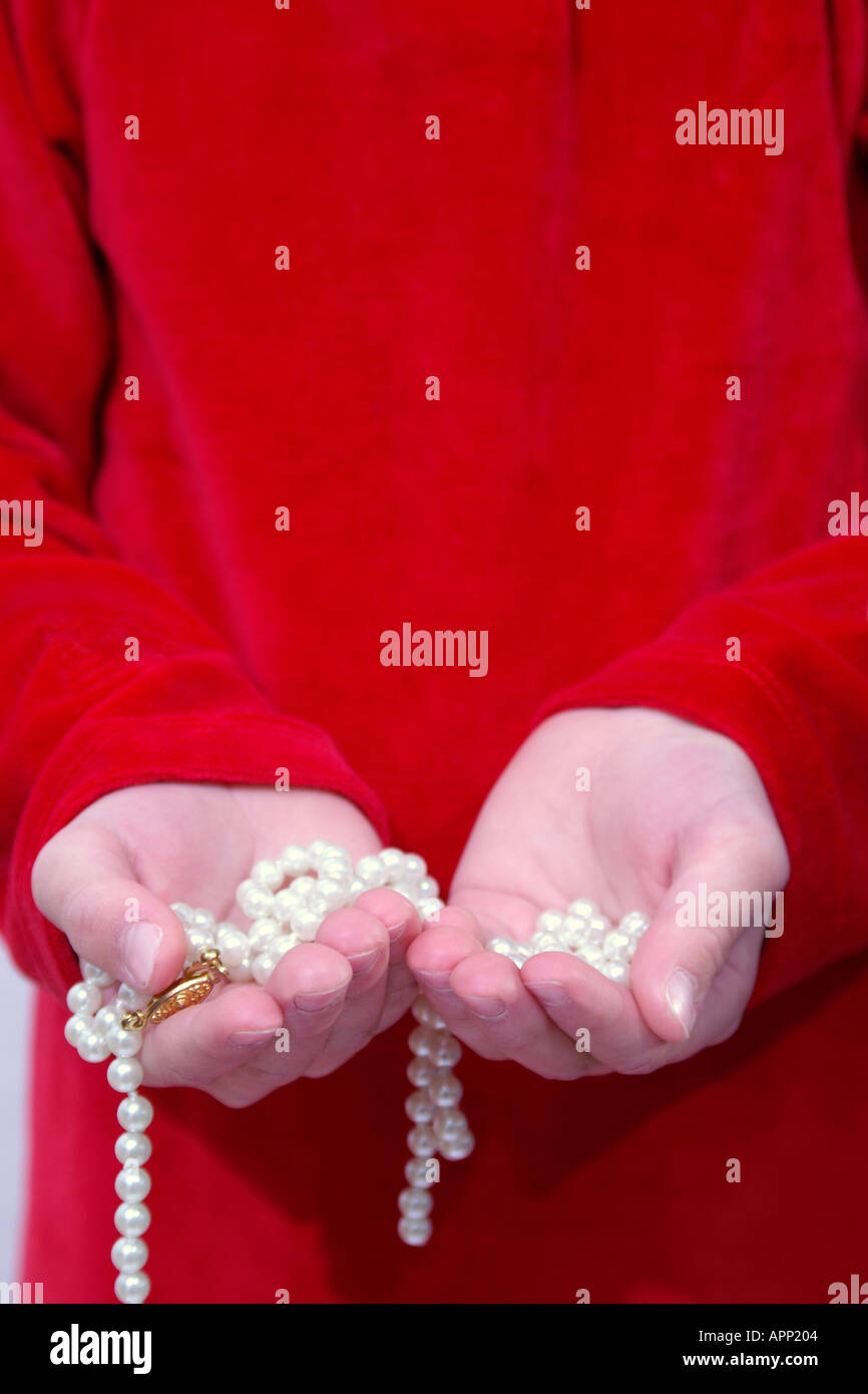 broken string of pearls in childs hands Stock Photo