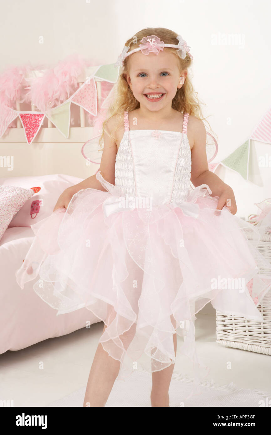 a girl plays dressing up in her bedroom and is dressed as a white fairy Stock Photo