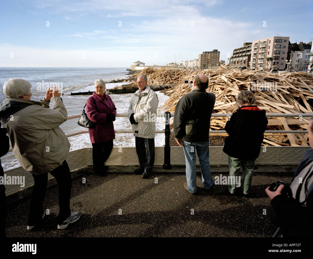Tourists posing in front of the washed up wood from the sunken Ice Prince Worthing Pier West Sussex England UK Stock Photo