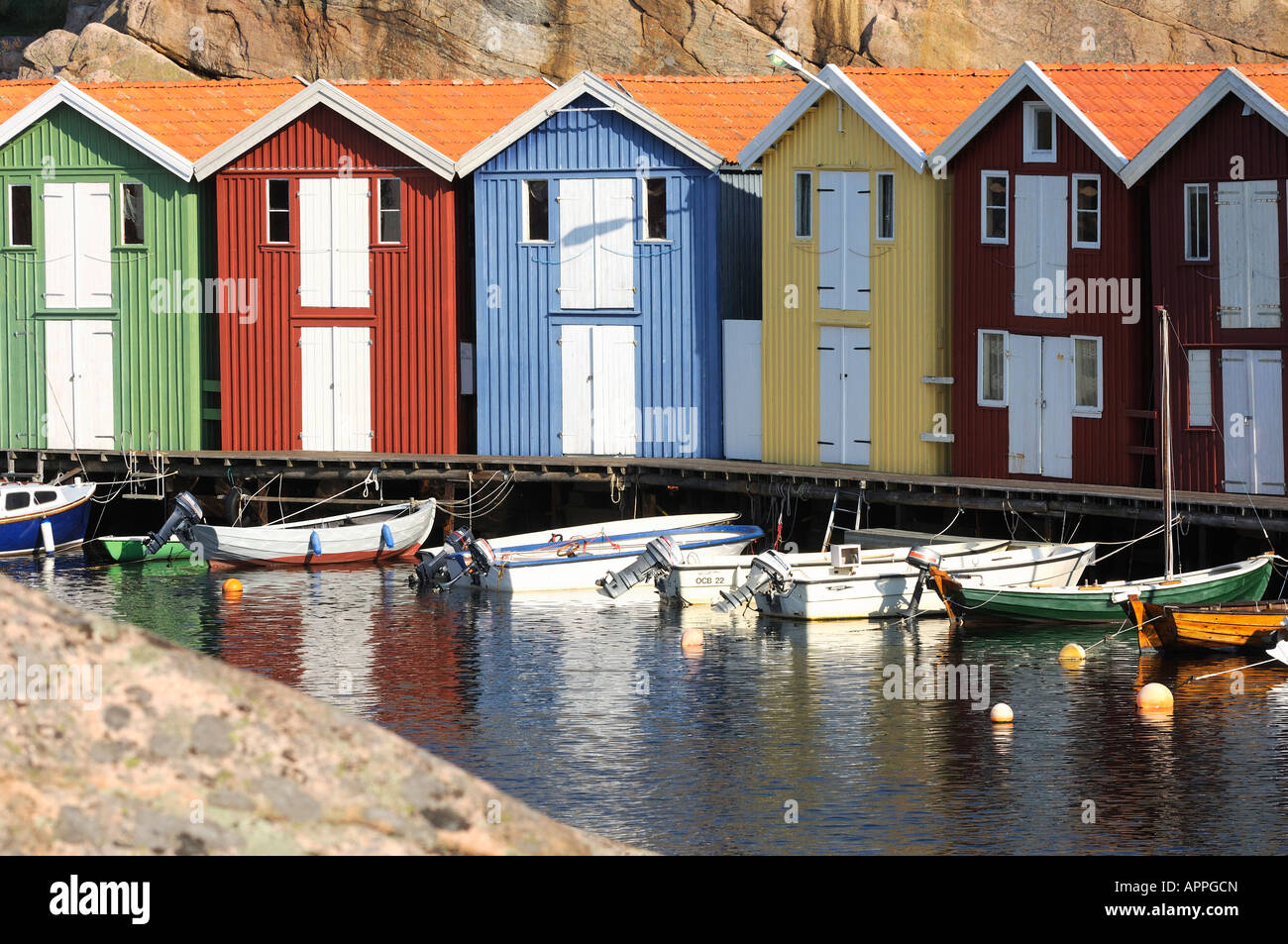 Beach huts and boats moored in sea, Smögen, Bohuslän, Sweden Stock Photo
