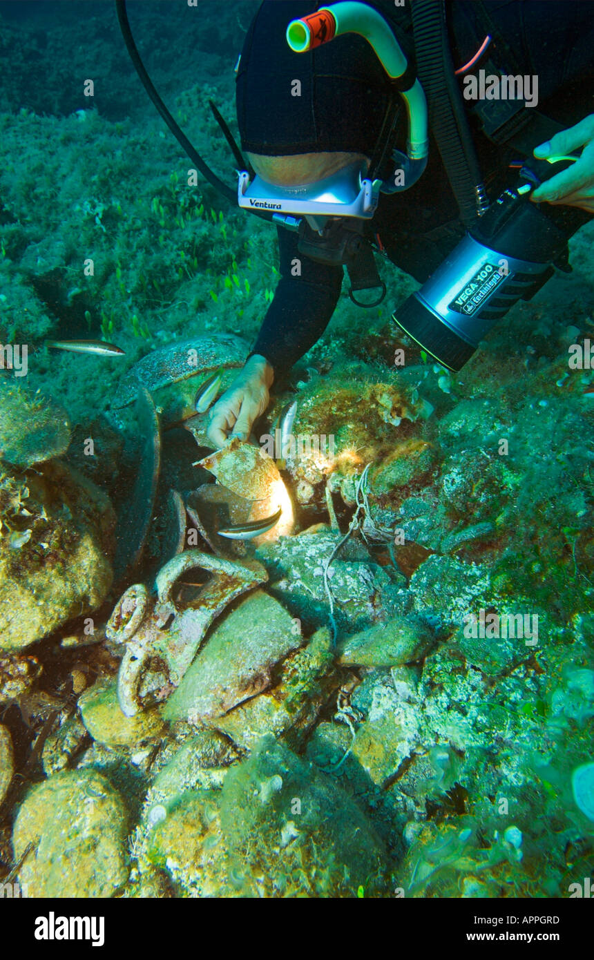 Diver finding amphora shards underwater from ancient shipwreck at Paros