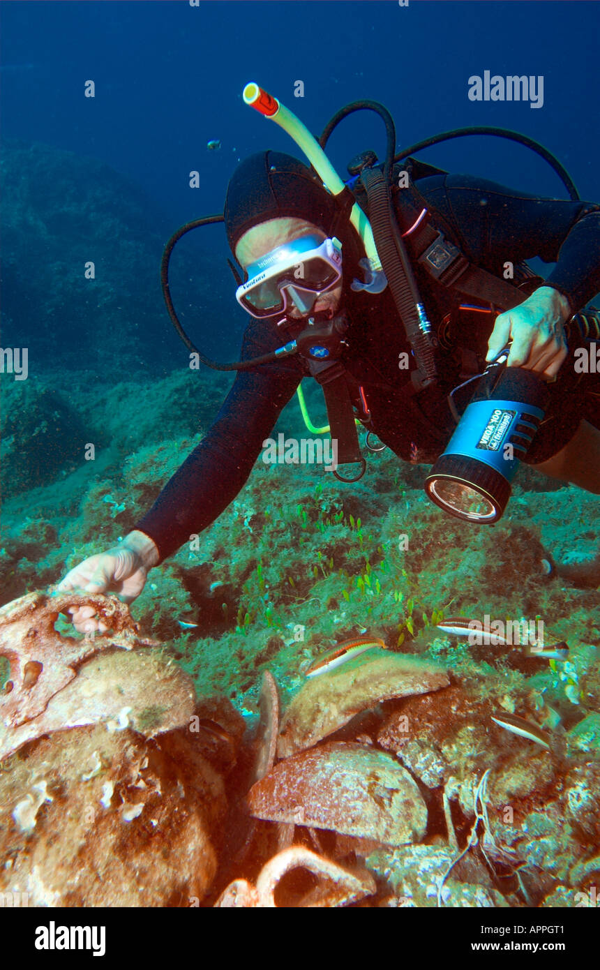 Diver finding amphora shards underwater from ancient shipwreck at Paros