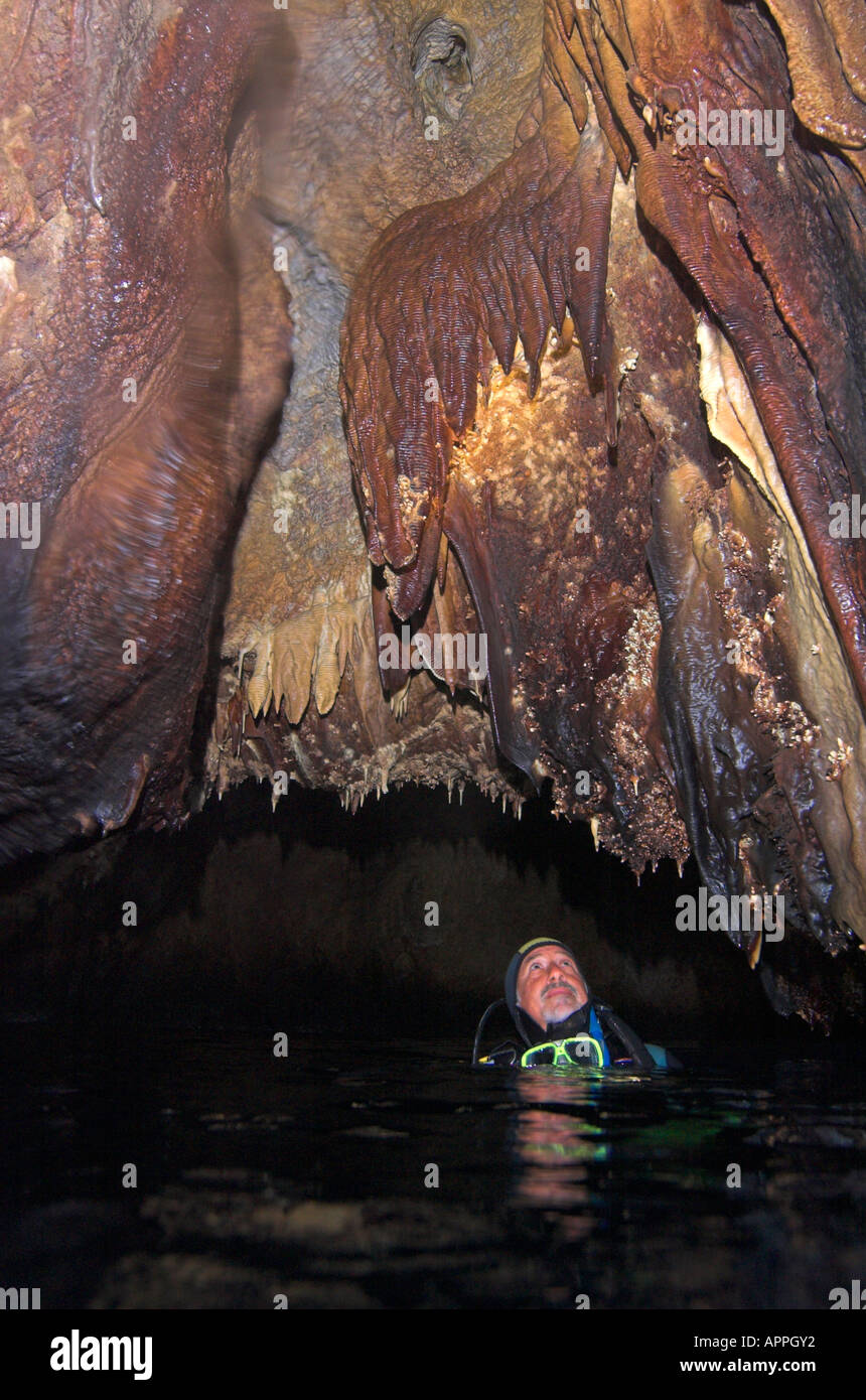 stalactites in sea cave on Island of Paderonisi being examined by scuba diver Stock Photo
