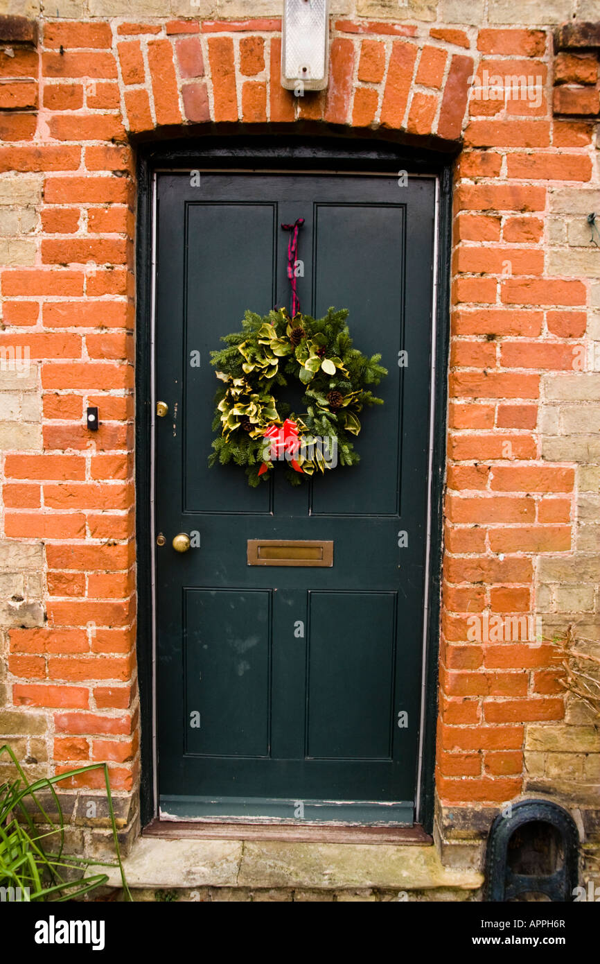 Christmas Wreath on Front Door of Brick Country Cottage Stock Photo