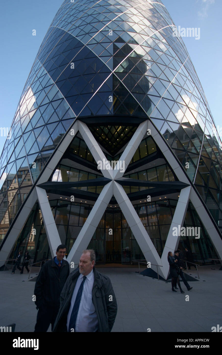 City workers walk past the front entrance 30 St Mary Axe in the City of London. Stock Photo