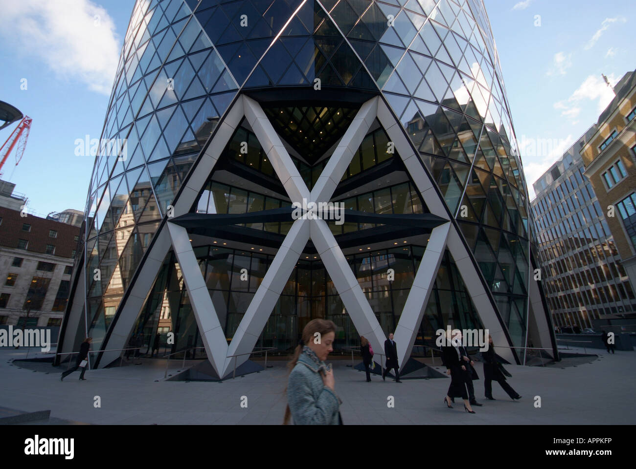 City workers walk past the front entrance 30 St Mary Axe in the City of London. Stock Photo