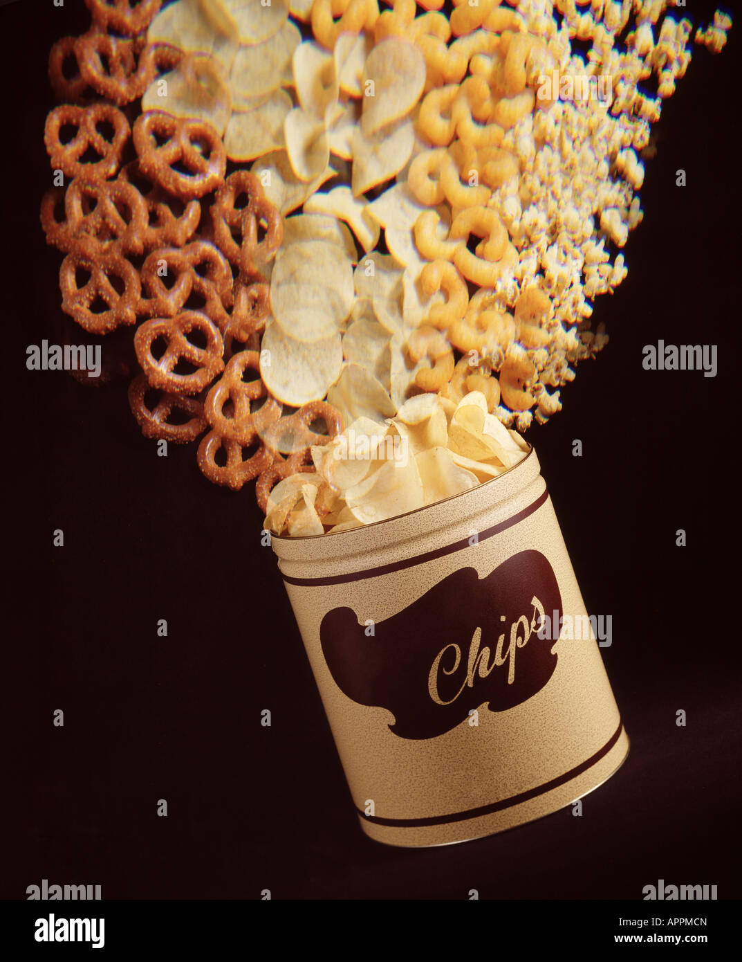 Exploding can of favorite american style snack foods, pretzels, potato chips, cheese corn curls and pop corn. Stock Photo