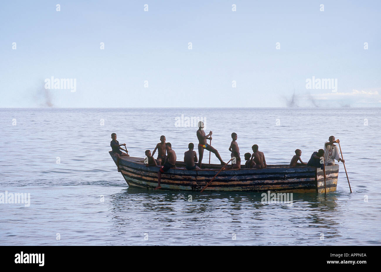Some children play in a fishing boat as a plague of flies sweeps like a cloud out of the Lake Malawi horizon Stock Photo