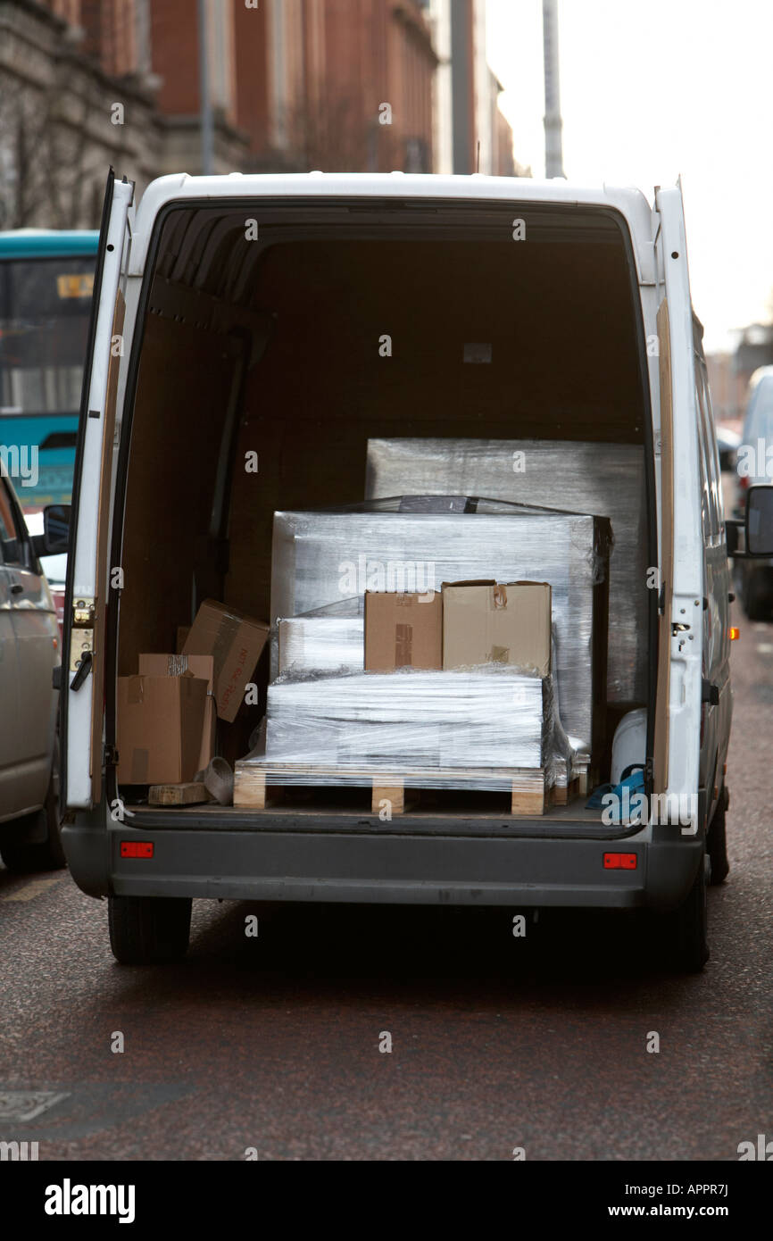 white van delivery vehicle containing wrapped pallet boxes double parked in  the road Belfast Northern Ireland UK Stock Photo - Alamy