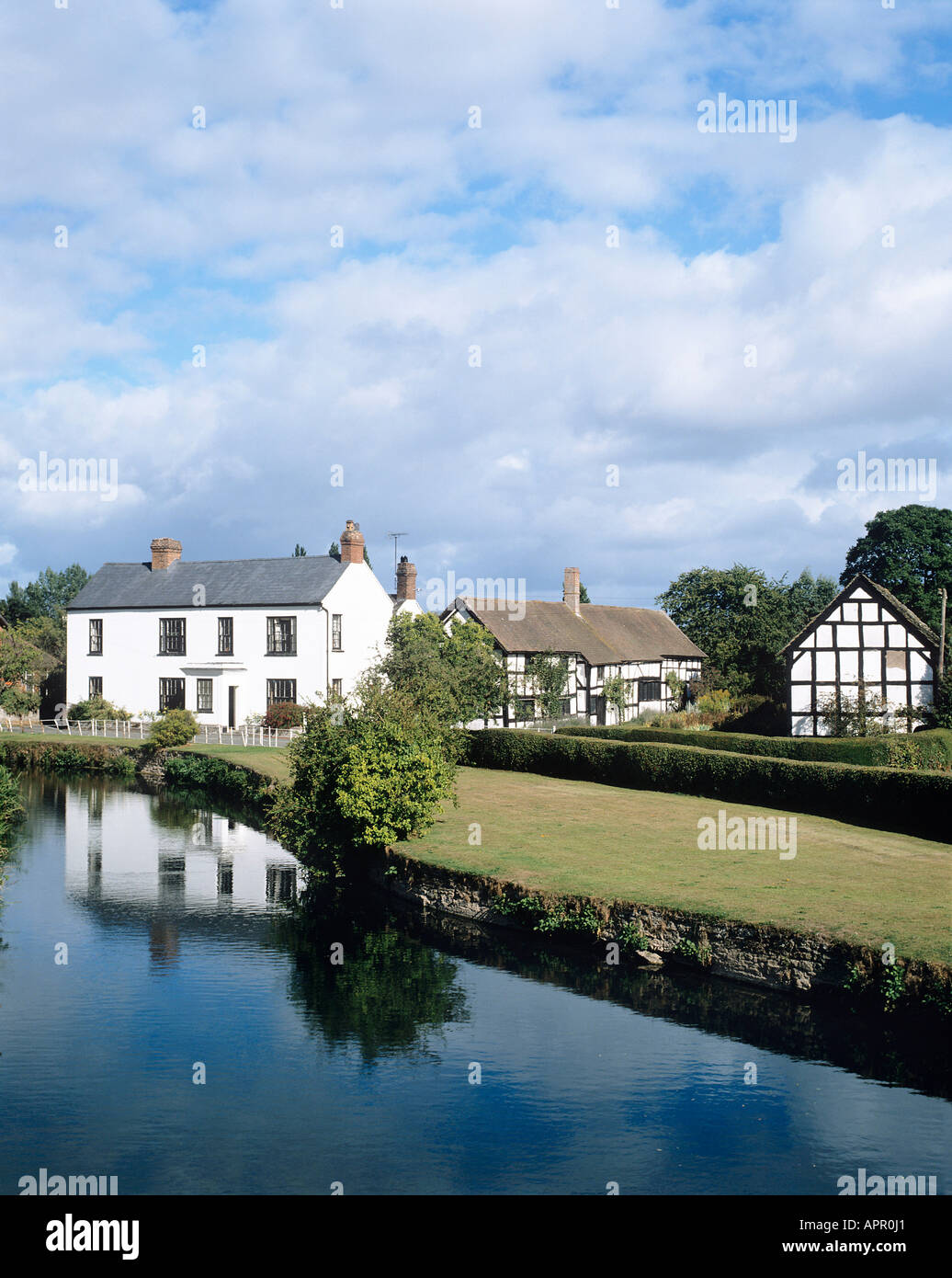 The timber framed houses of this village are grouped around the millpond beside the River Arrow Stock Photo