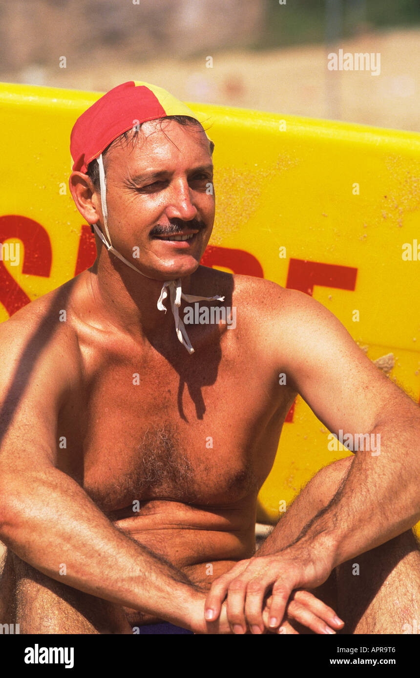 A lifeguard on Bondi Beach wearing a red and yellow skull cap type hat to  distinguish himself Stock Photo - Alamy