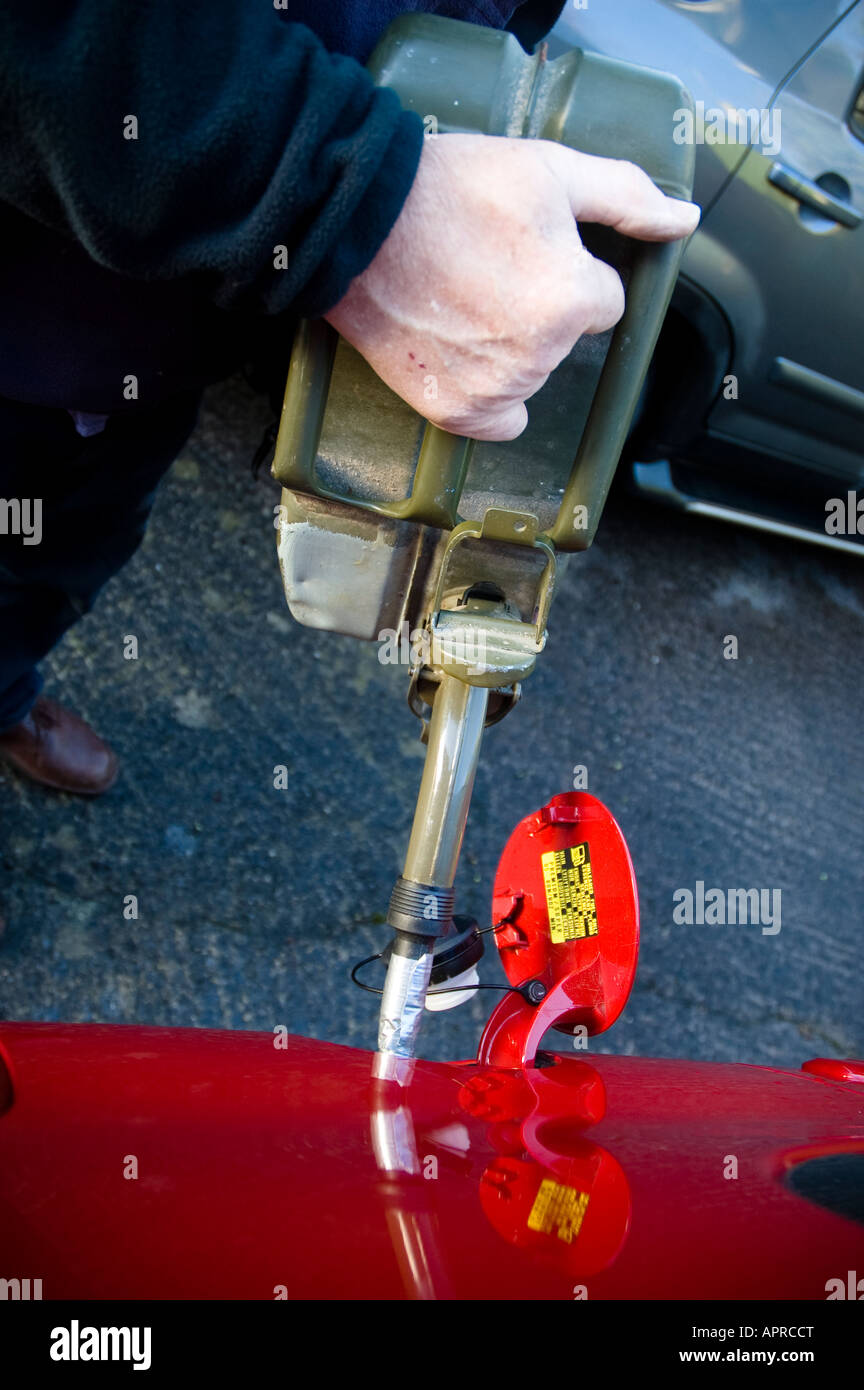 Filling car petrol tank from Jerry can of spare fuel Stock Photo Alamy
