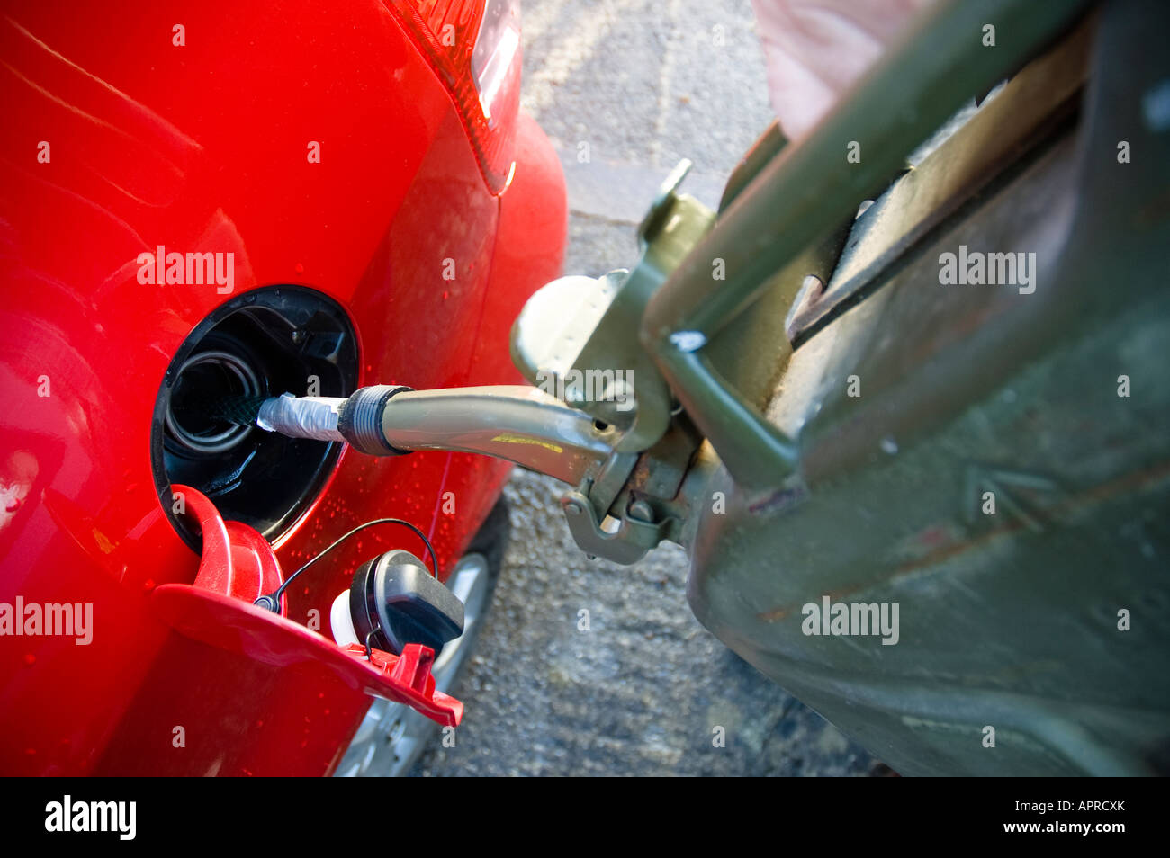Filling car petrol tank from Jerry can of spare fuel Stock Photo Alamy