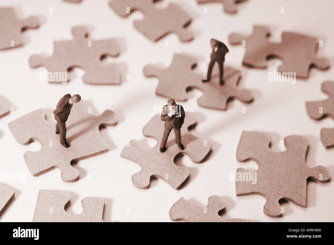Businessman Figures on Puzzle Pieces Stock Photo