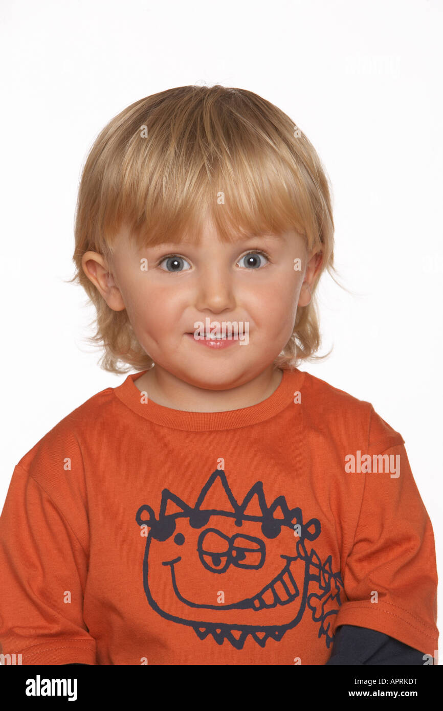a boy in an orange tshirt smiles against a white background Stock