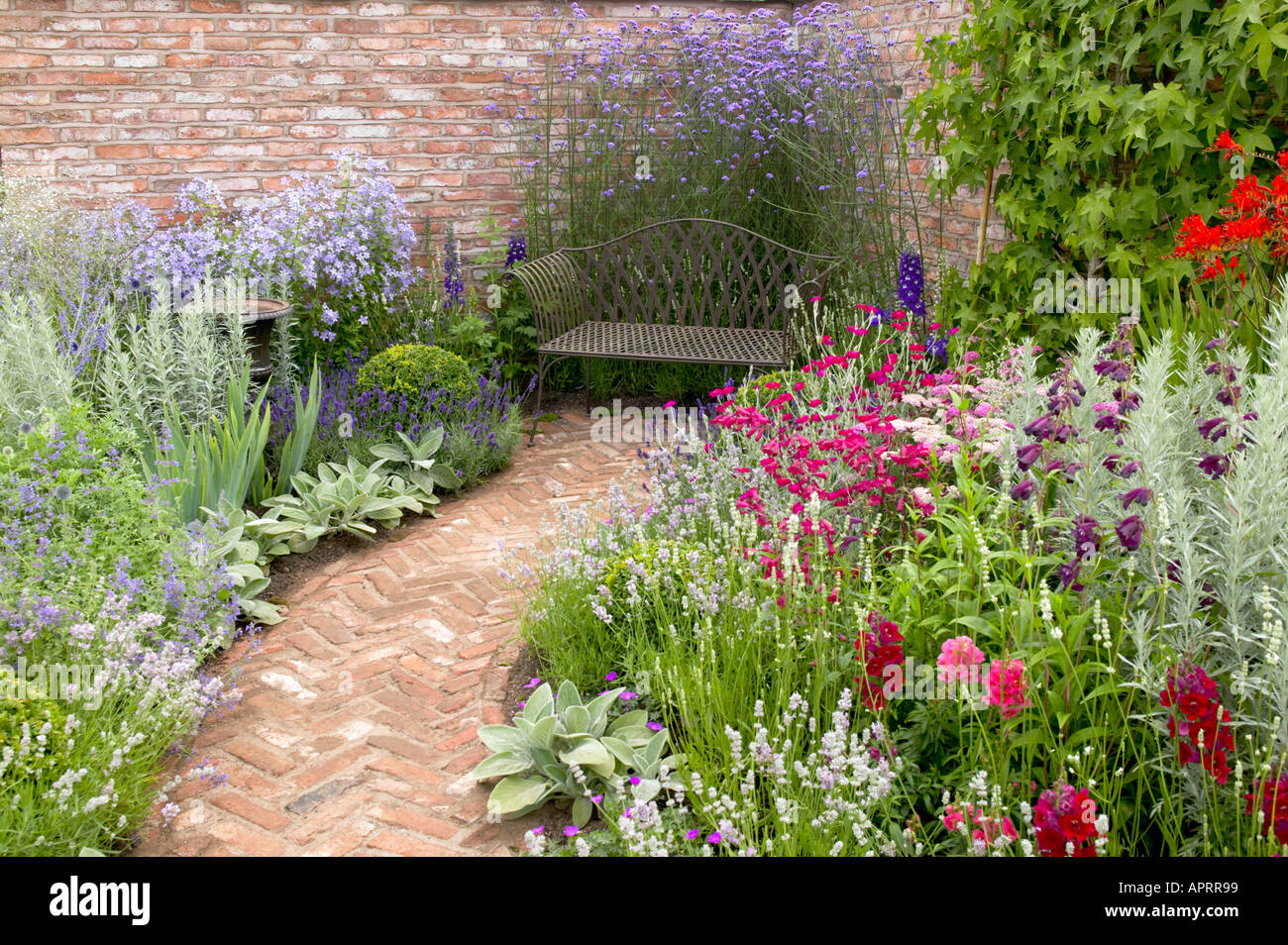 Tatton Flower Show herringbone brick garden path with iron bench Stock Photo