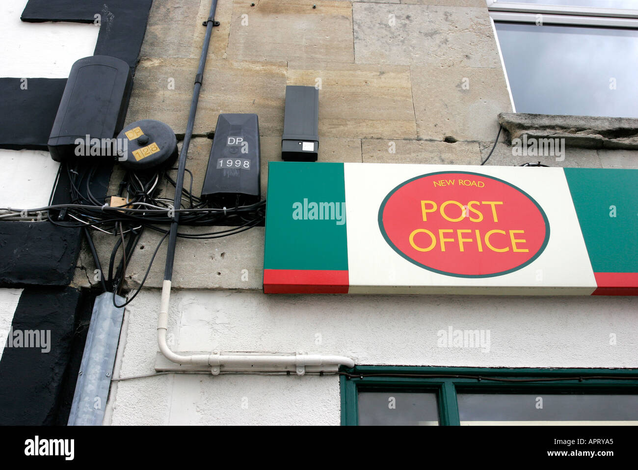 Post Office shop sign and untidy electricity junction boxes and wires