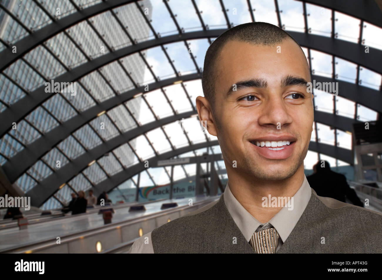 young mixed race businessman on escalators on underground Stock Photo